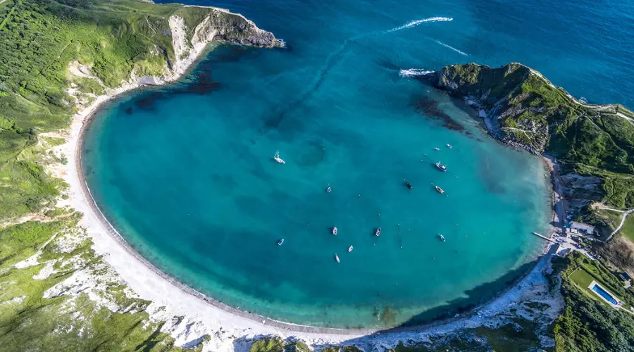 The brilliant turquoise waters of Lulworth Cove serve as the focal point