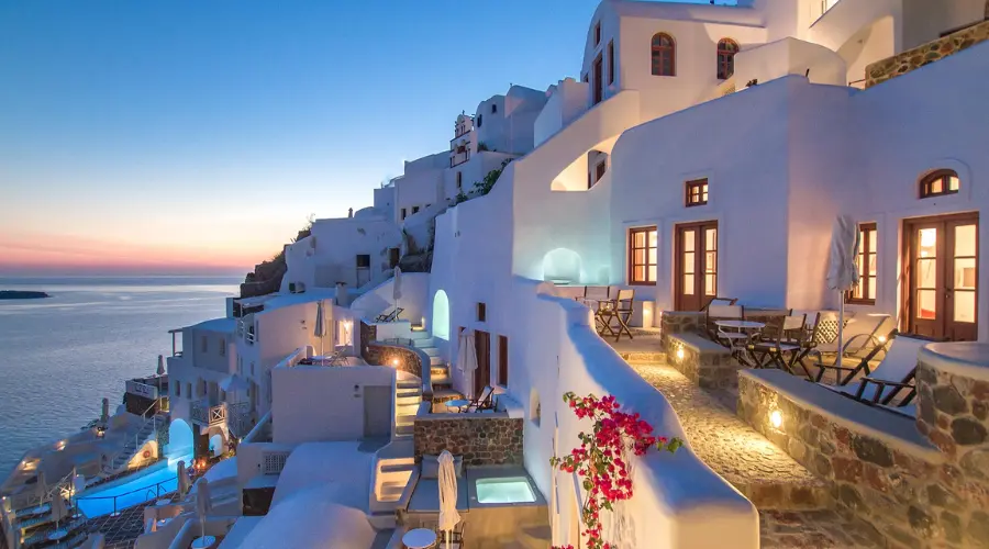 white buildings with blue domes set against a stunning ocean vista 